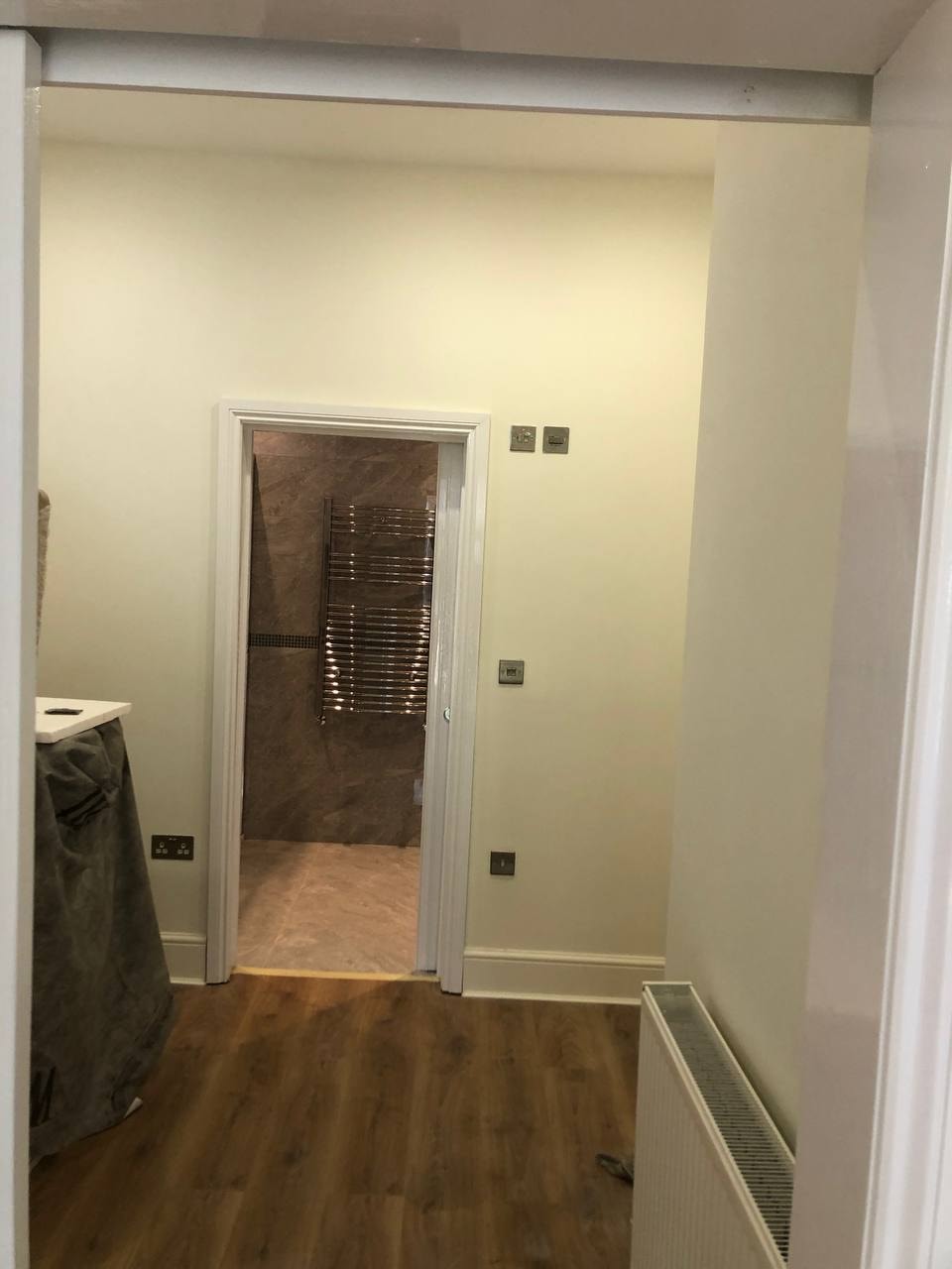 Bathroom entrance with cream walls and wood flooring — West London