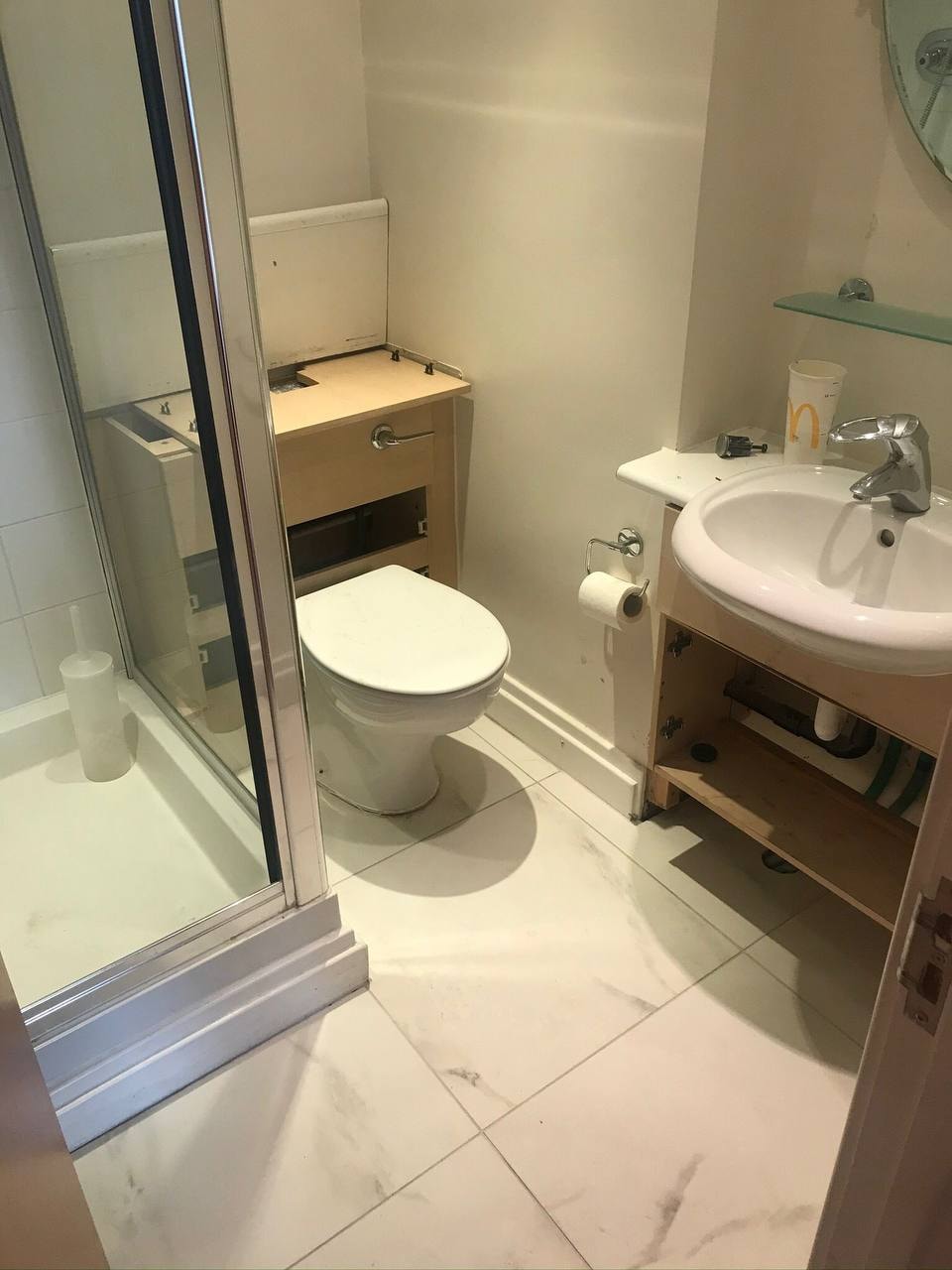 Marble-effect floor tiling in bathroom with shower enclosure — West London