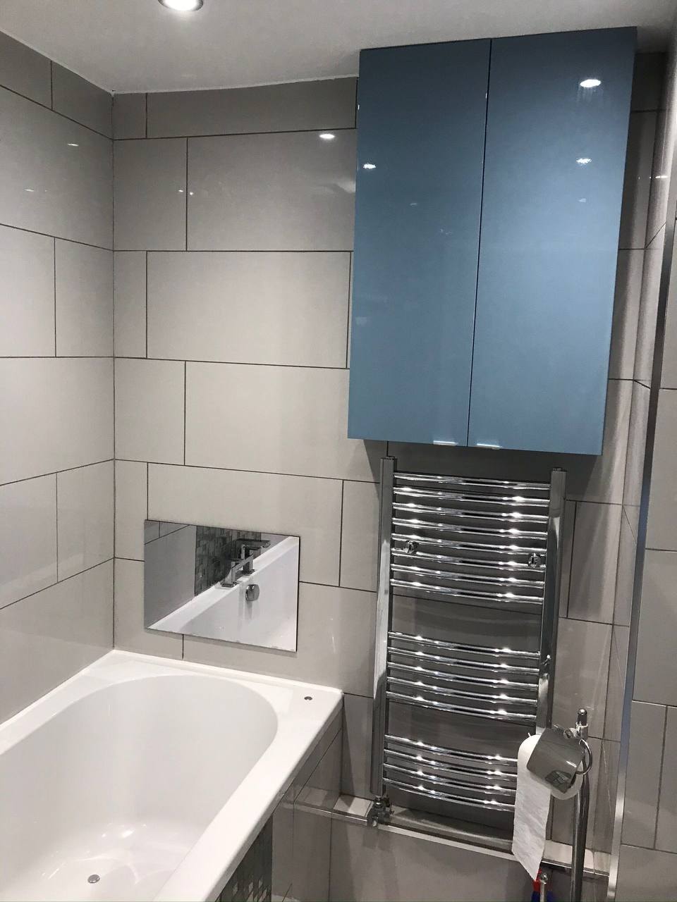 Completed bathroom with marble-effect wall tiling and vanity — West London